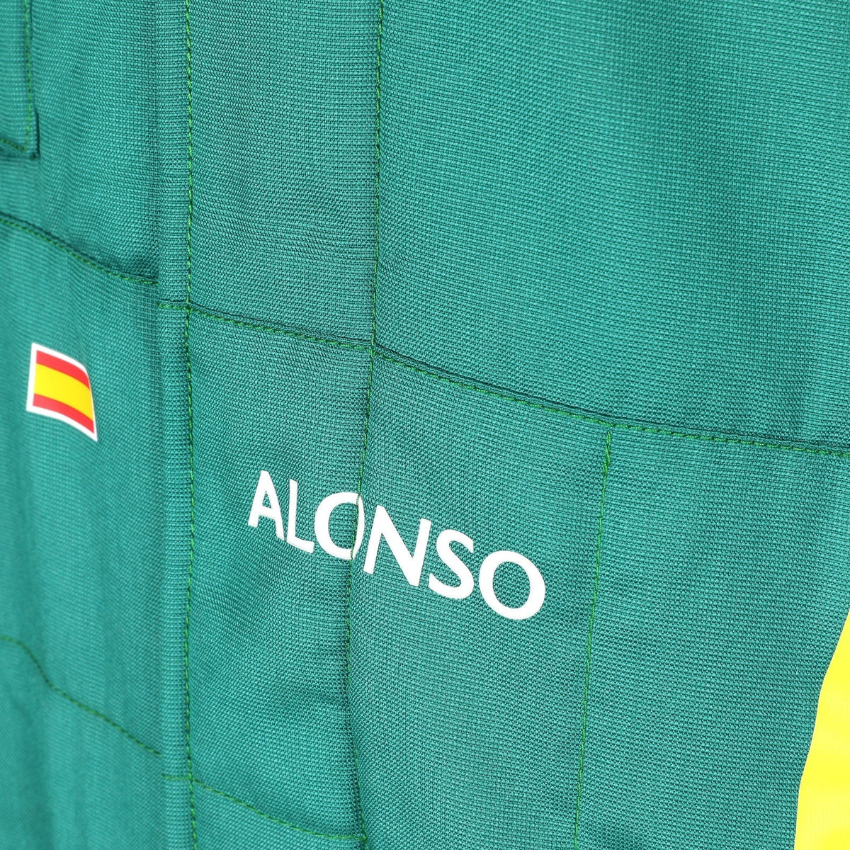  Alonso name and Spanish flag detail on the green 2026 Aston Martin F1 race suit – Trending Racegear.
